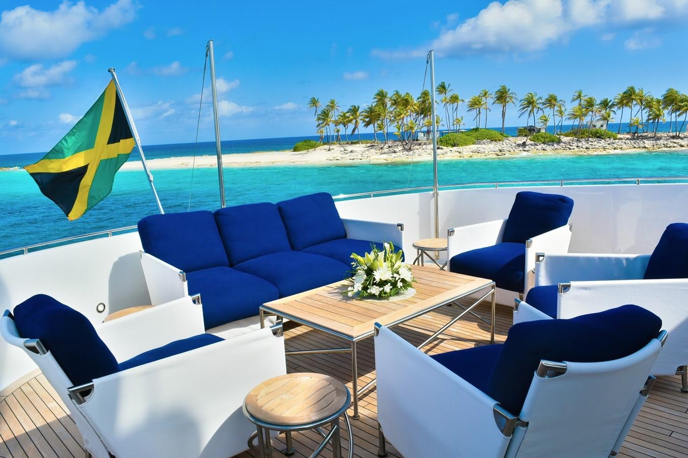 a table and chairs on a beach aboard OCTOPUSSY Yacht for Sale