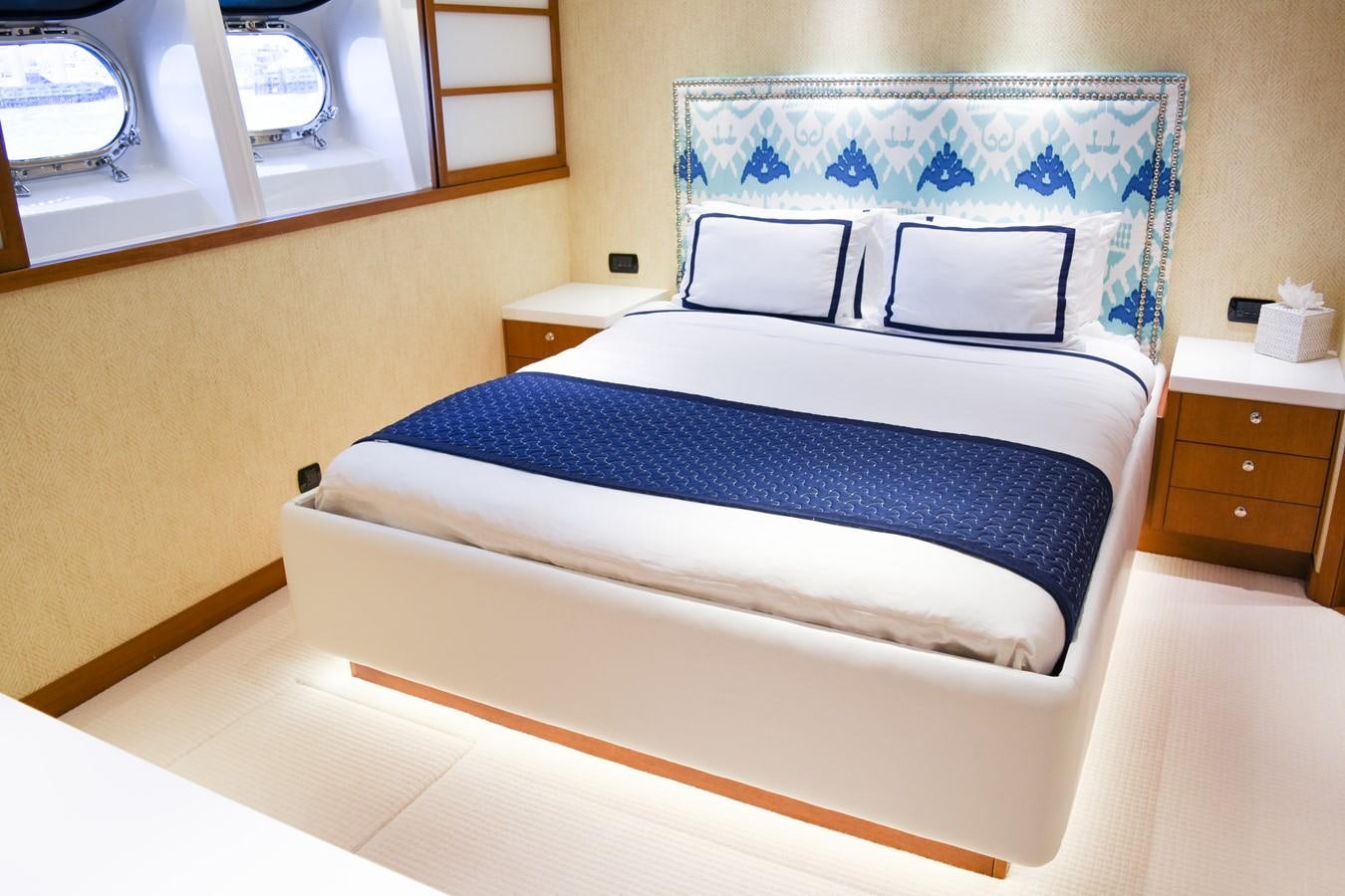 a bed with blue and white sheets aboard OCTOPUSSY Yacht for Sale