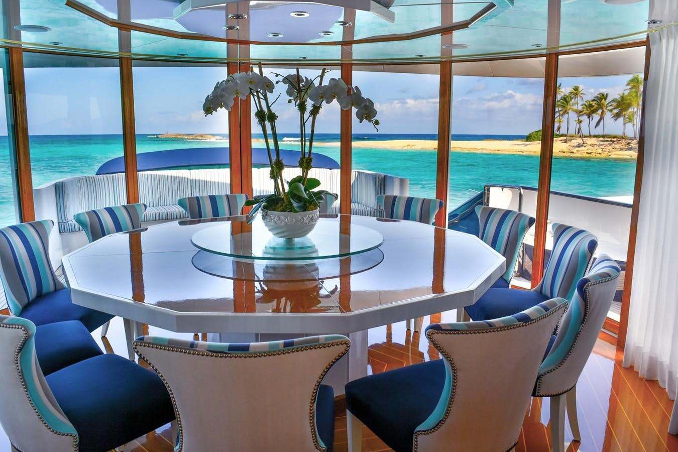a table with chairs and a plant on it aboard OCTOPUSSY Yacht for Sale