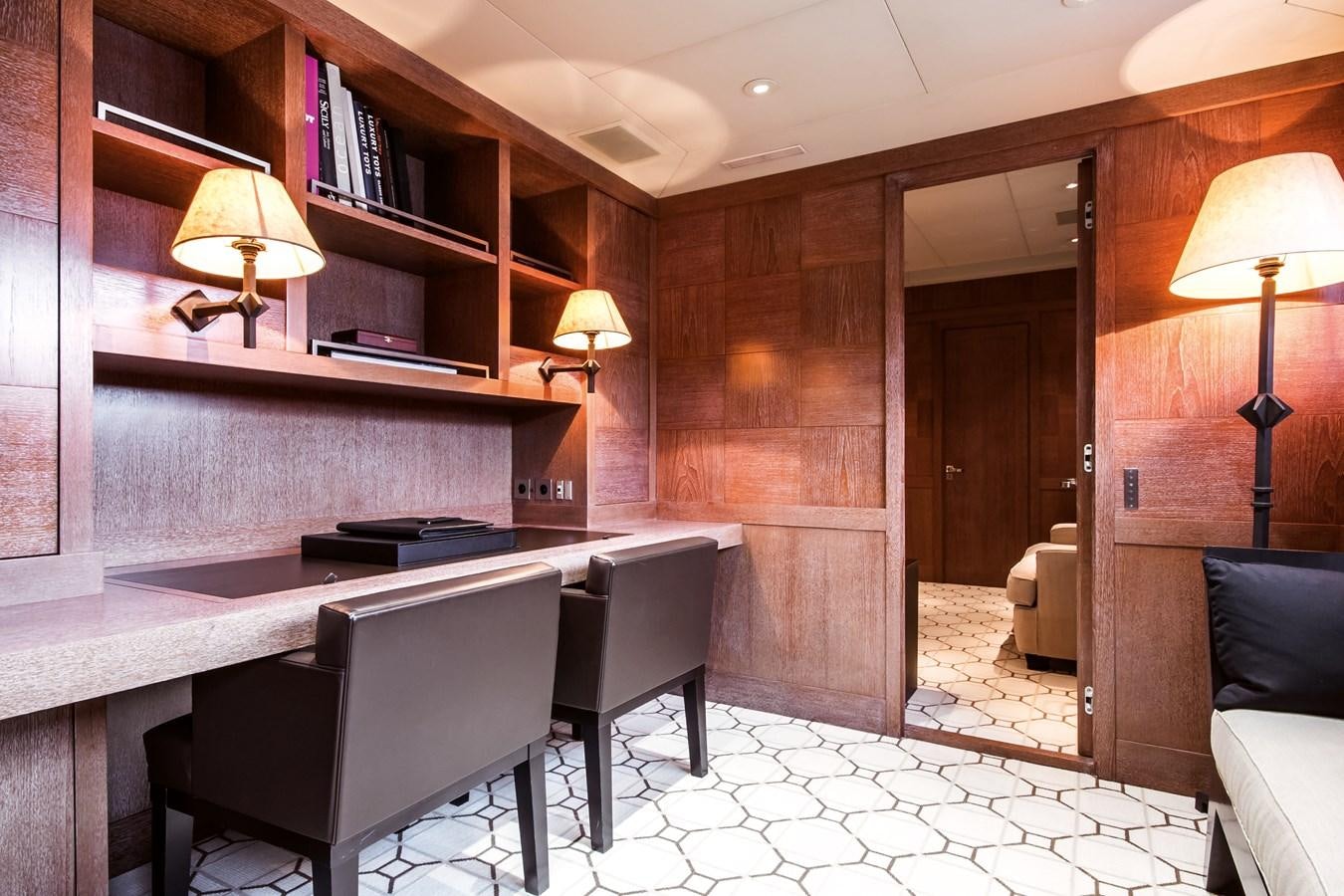 a room with a piano and a desk and a lamp aboard ELEMENT Yacht for Charter