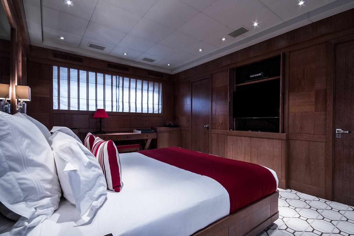 a room with a bed and a television aboard ELEMENT Yacht for Charter