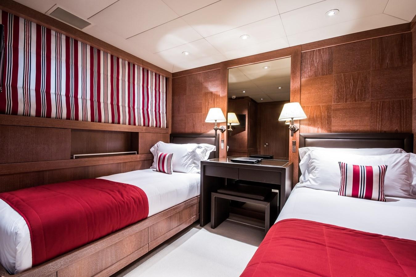 a room with beds and a mirror aboard ELEMENT Yacht for Charter