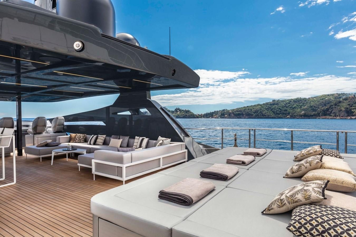 a large lounge area with a large body of water and a large boat in the background aboard TOUCH ME Yacht for Sale