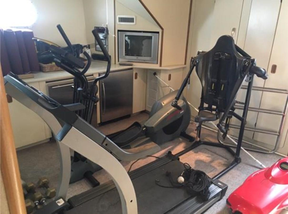 a room with a group of exercise equipment aboard MCY Yacht for Sale