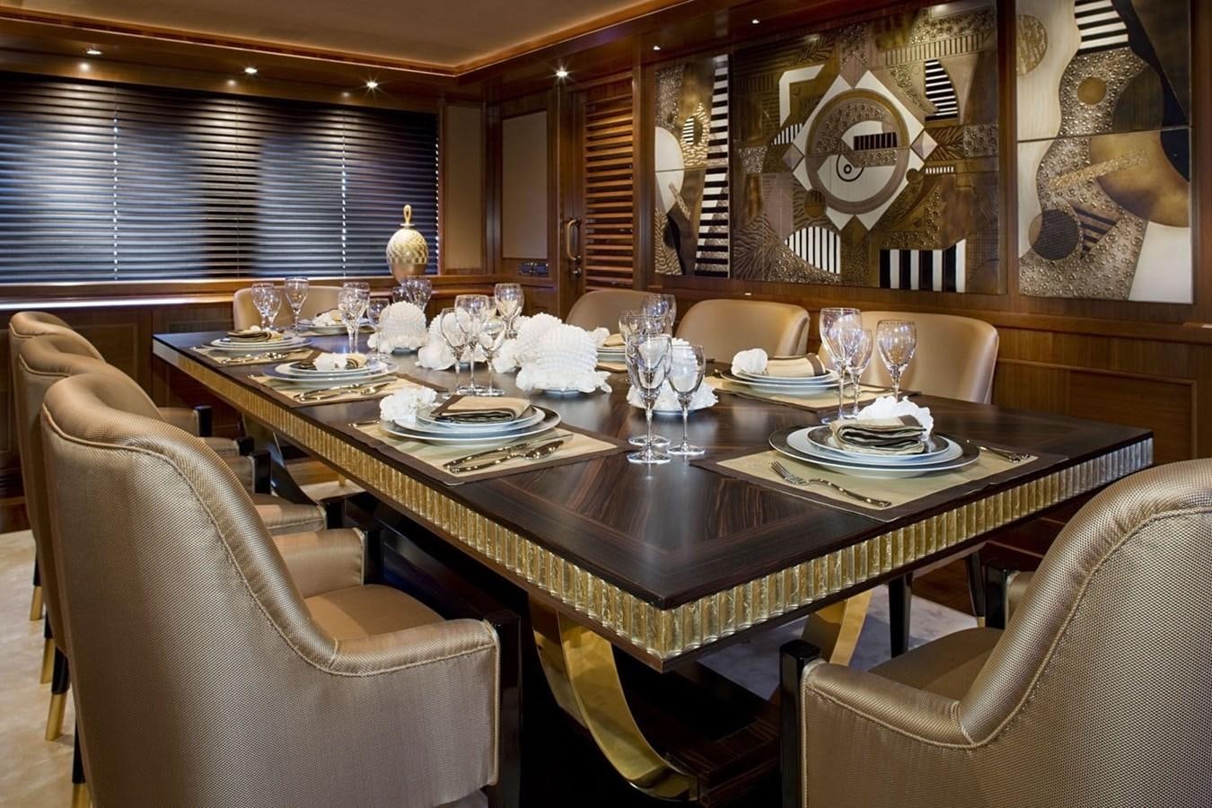 a dining table with plates and chairs aboard BEHIKE Yacht for Sale