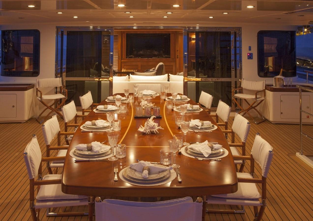 a large dining table with plates and chairs aboard BEHIKE Yacht for Sale