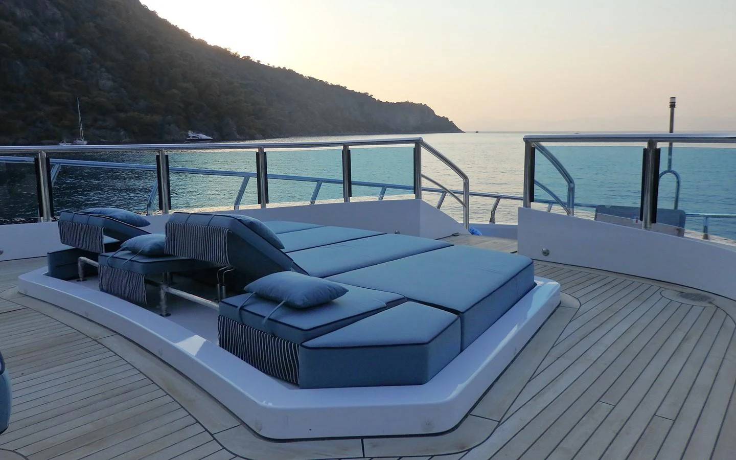 a large bed on a deck overlooking a body of water aboard DESTINY Yacht for Sale