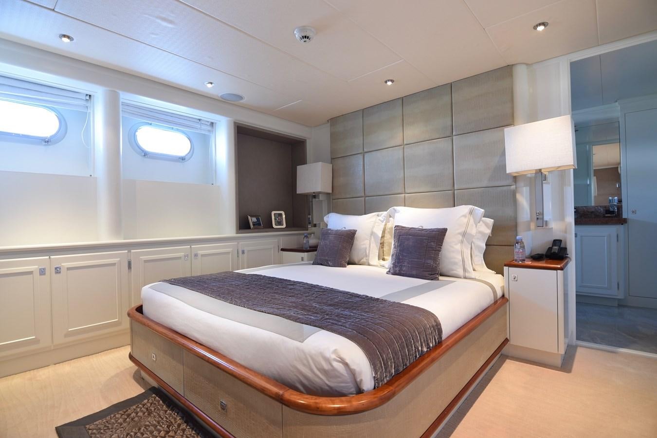 a bedroom with a bed and a desk aboard LIFE SAGA Yacht for Sale