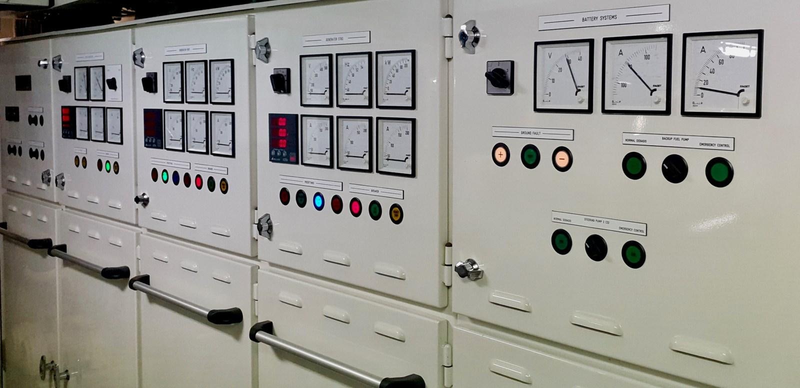a white wall with black and green buttons and switches aboard LIFE SAGA Yacht for Sale