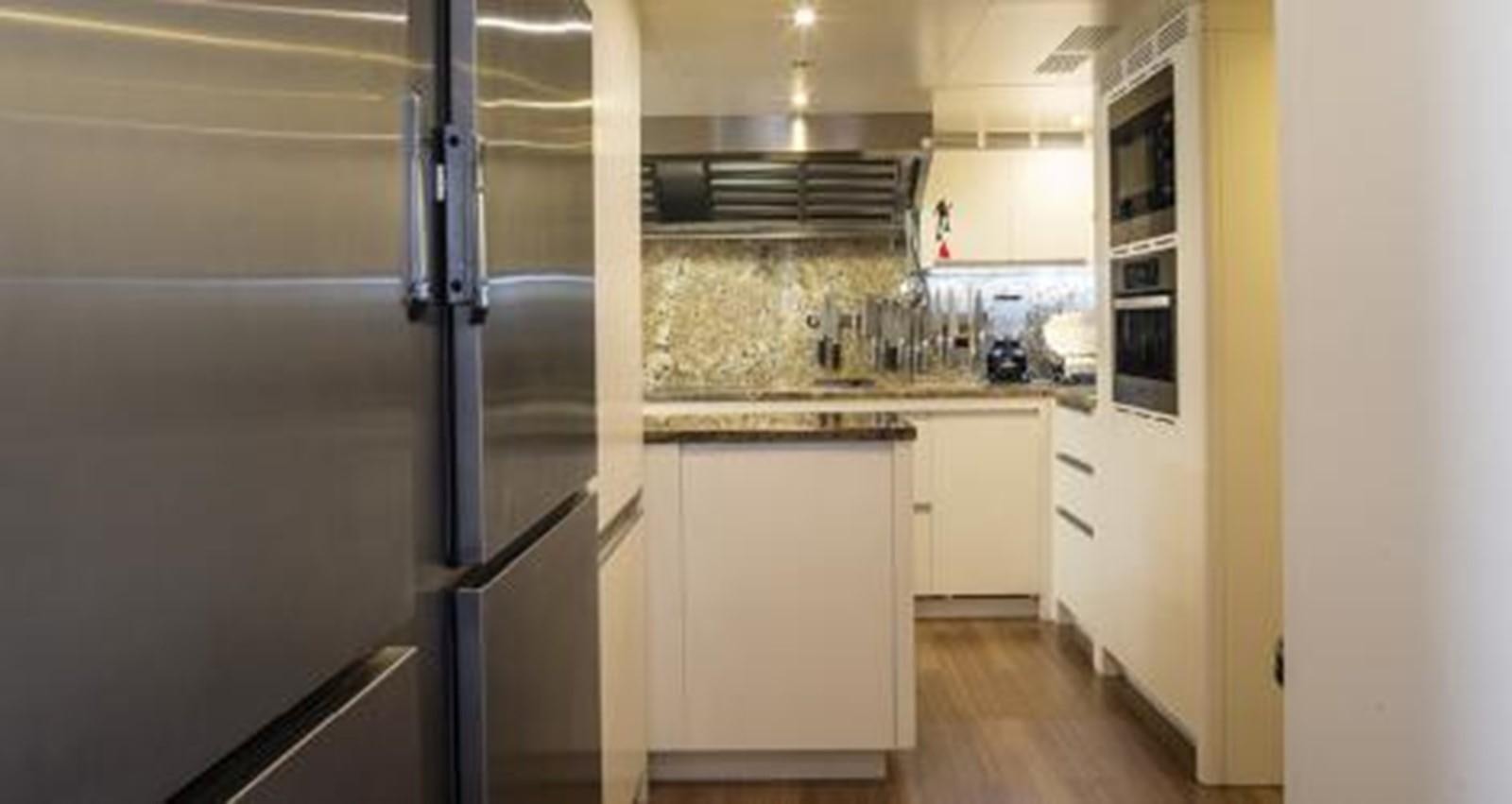 a kitchen with a stainless steel refrigerator aboard NELA Yacht for Sale