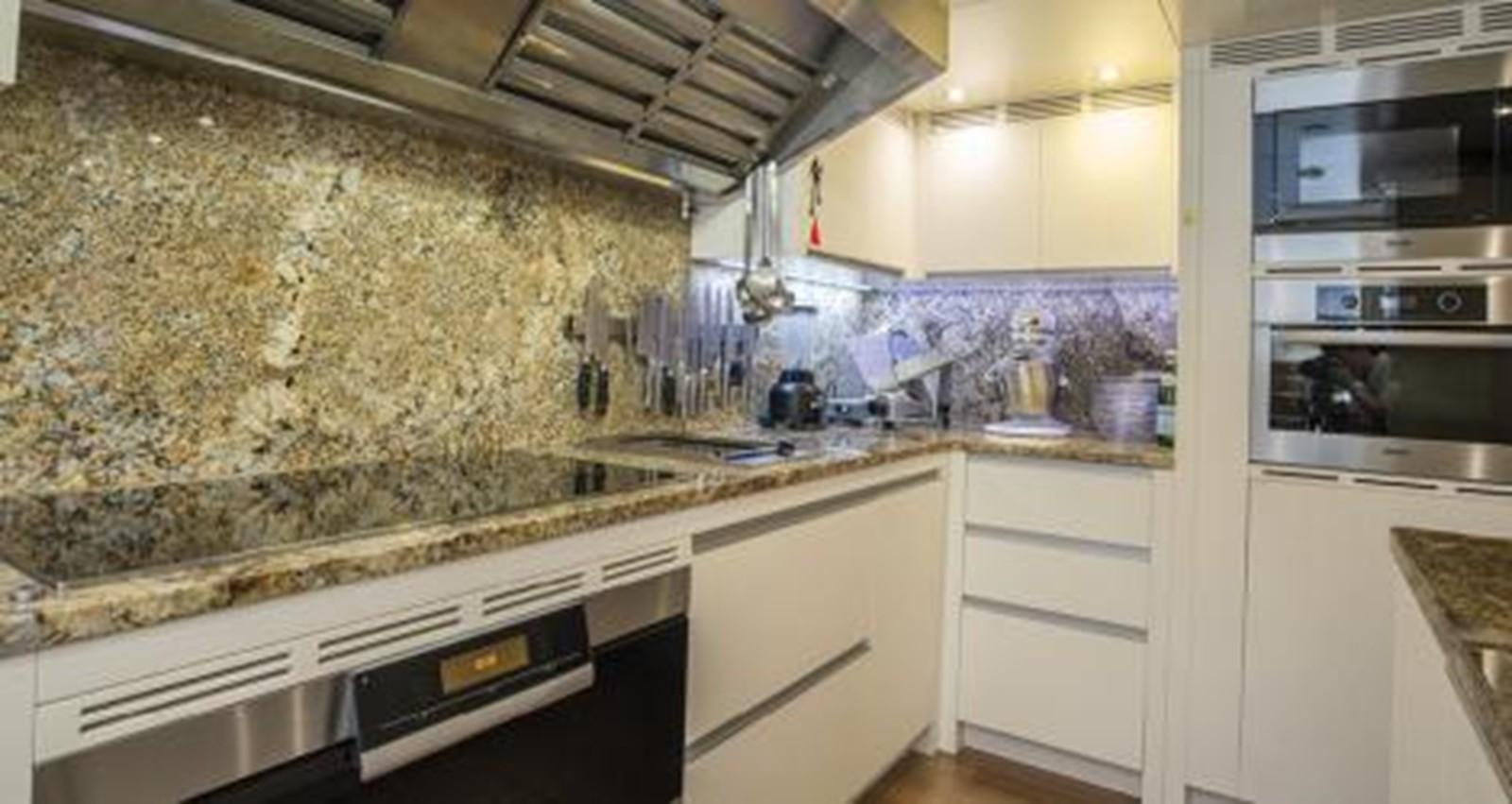 a kitchen with a large marble counter top and a microwave oven aboard NELA Yacht for Sale
