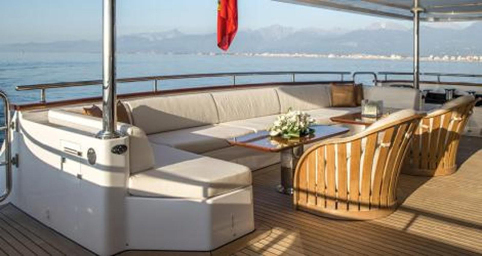 a room with a couch and a table and chairs aboard NELA Yacht for Sale