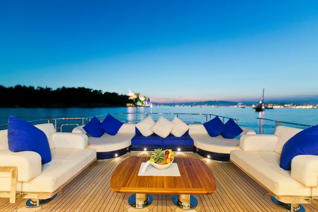 a table with a plate on it next to a pool of water aboard AK ROYALTY Yacht for Sale