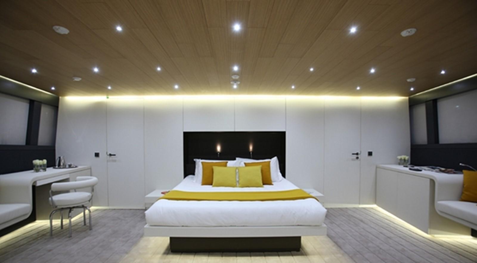 a room with a bed and a desk aboard OCEAN SAPPHIRE Yacht for Sale