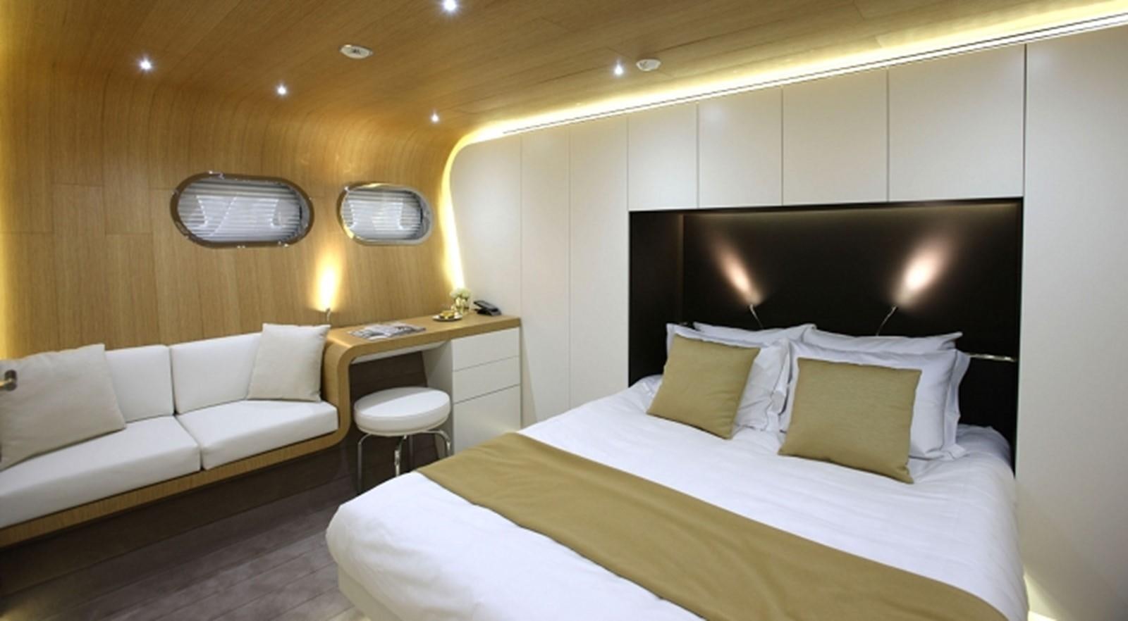 a room with a bed and a desk aboard OCEAN SAPPHIRE Yacht for Sale