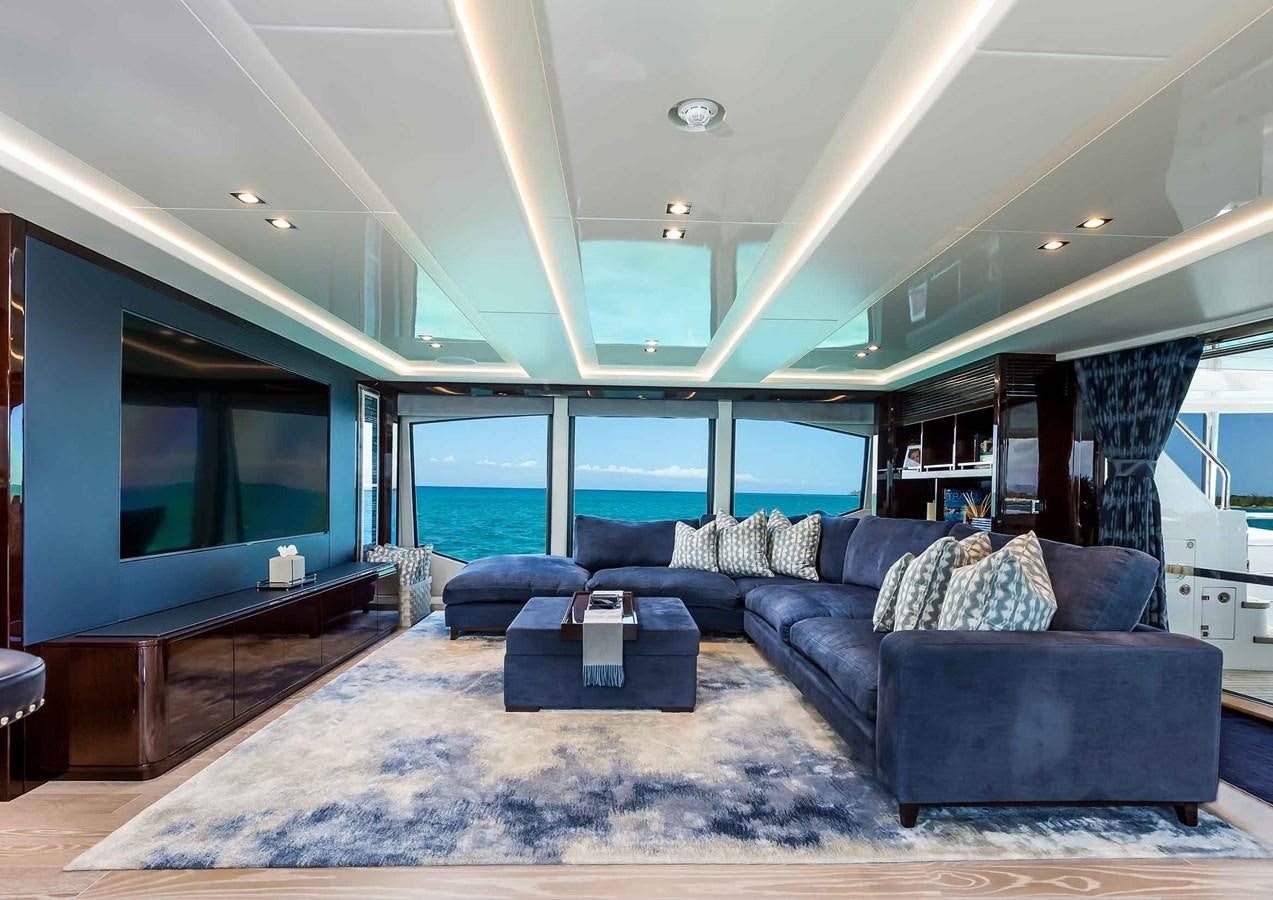a living room with a large blue couch and a large flat screen television aboard CAPTAIN MORGAN III Yacht for Sale
