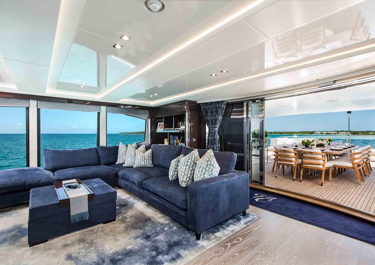a living room with a large blue couch and a large swimming pool aboard CAPTAIN MORGAN III Yacht for Sale