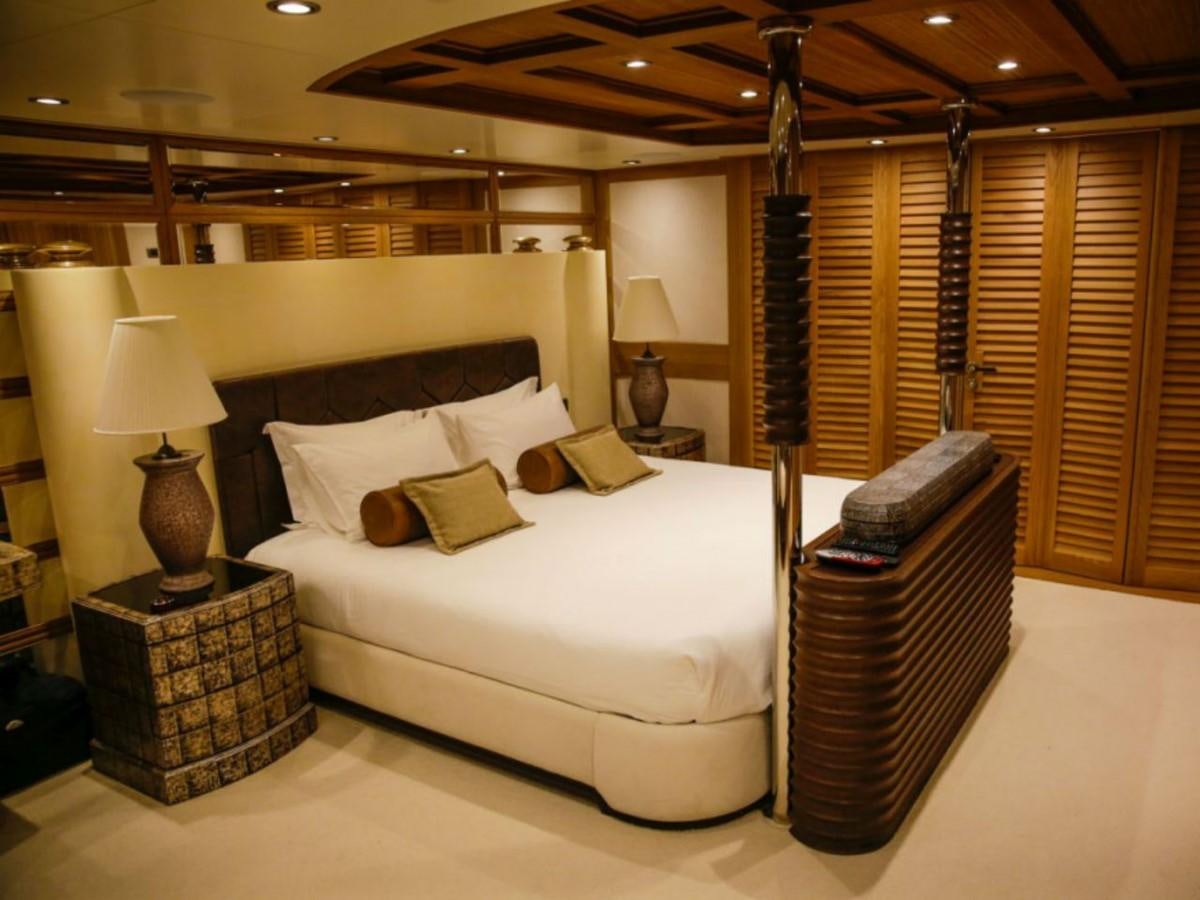 a bed with a chair and a table in a room aboard ZANZIBA Yacht for Sale