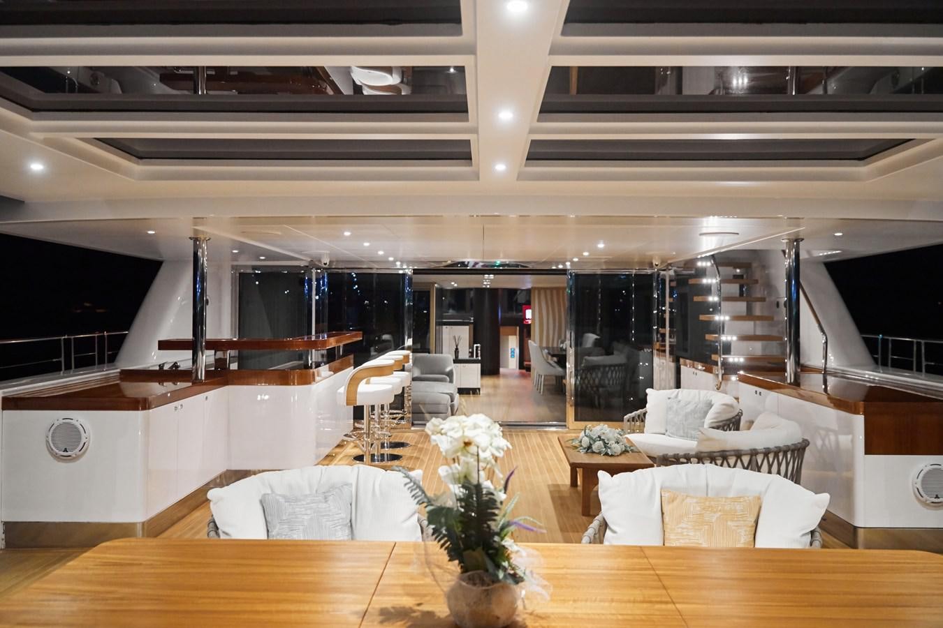 a large room with white chairs and a staircase aboard NORTH STAR Yacht for Sale