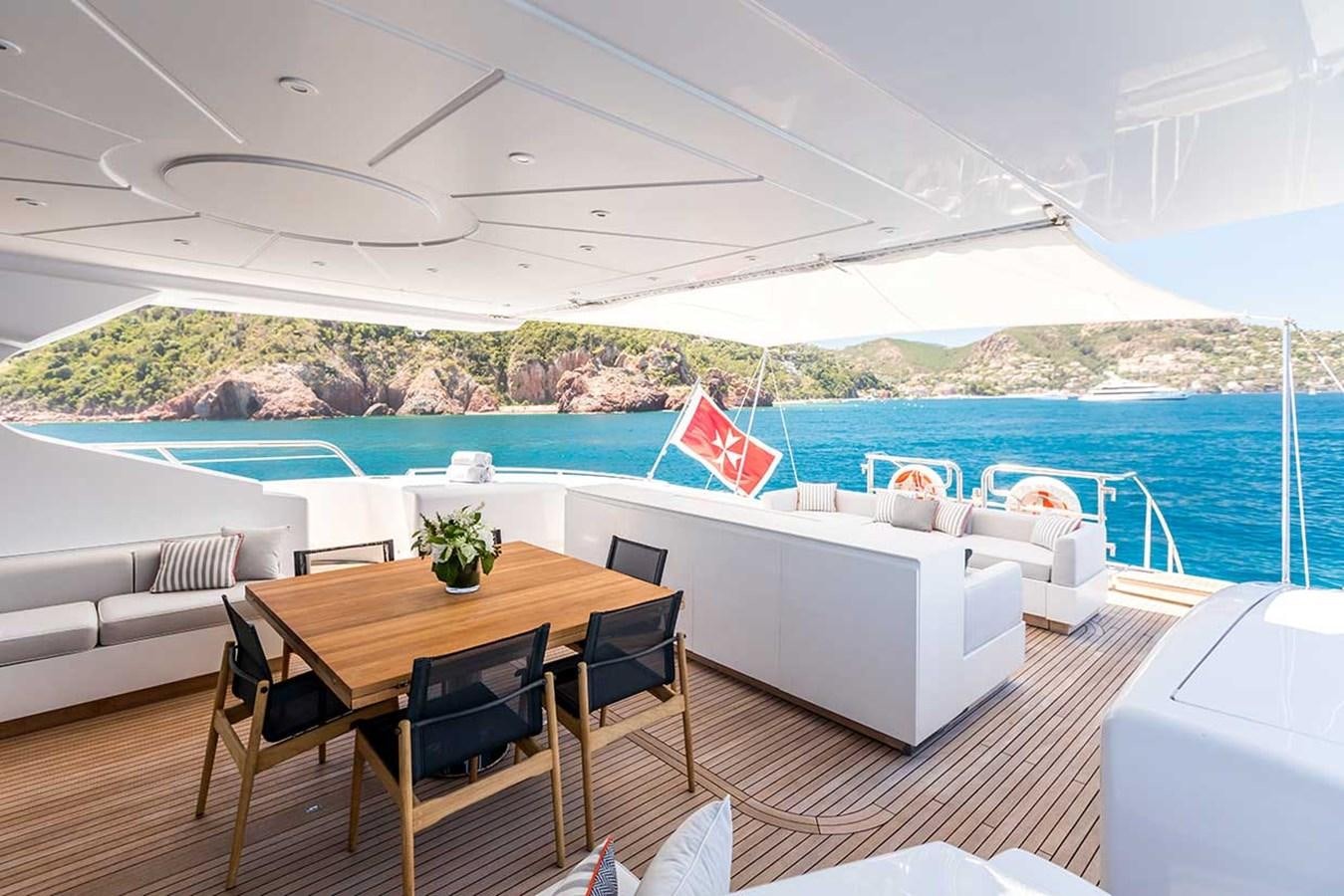 a table and chairs on a deck aboard BEACHOUSE Yacht for Sale