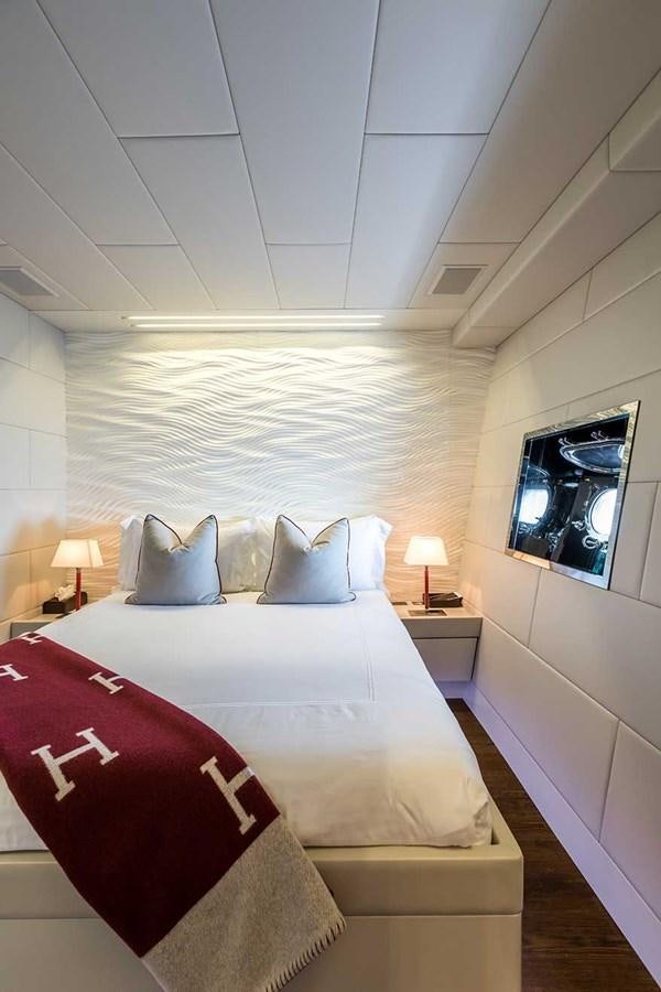 a bed with a white and red blanket and pillows aboard BEACHOUSE Yacht for Sale