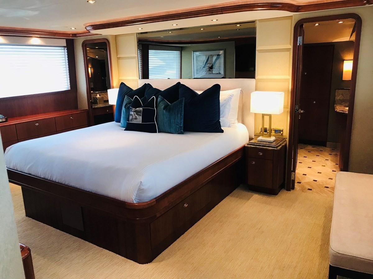 a bed with a white bed spread aboard RELENTLESS Yacht for Sale