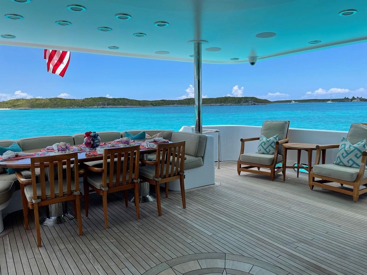 a deck with chairs and tables on it aboard RELENTLESS Yacht for Sale