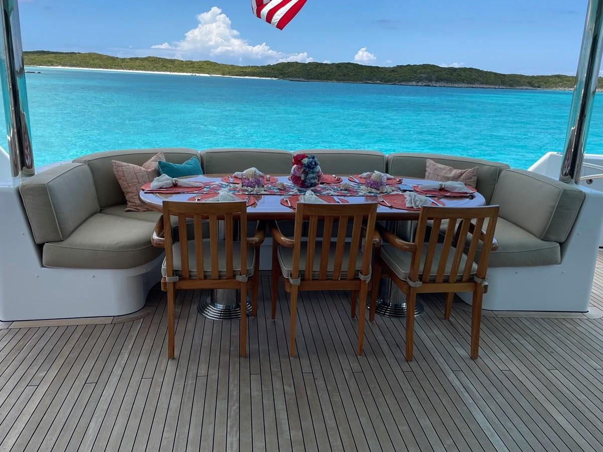 a table set up on a deck overlooking a body of water aboard RELENTLESS Yacht for Sale