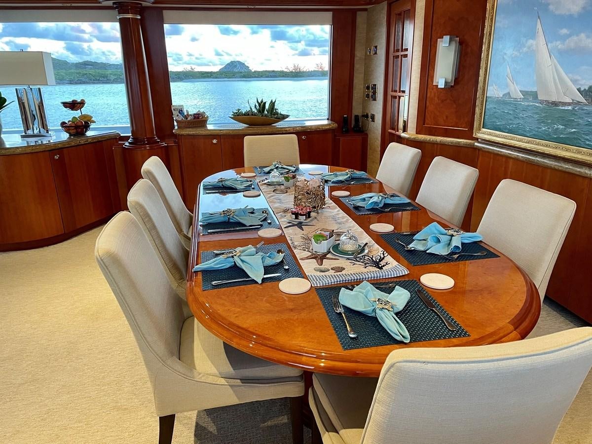 a dining table with chairs and a window aboard RELENTLESS Yacht for Sale