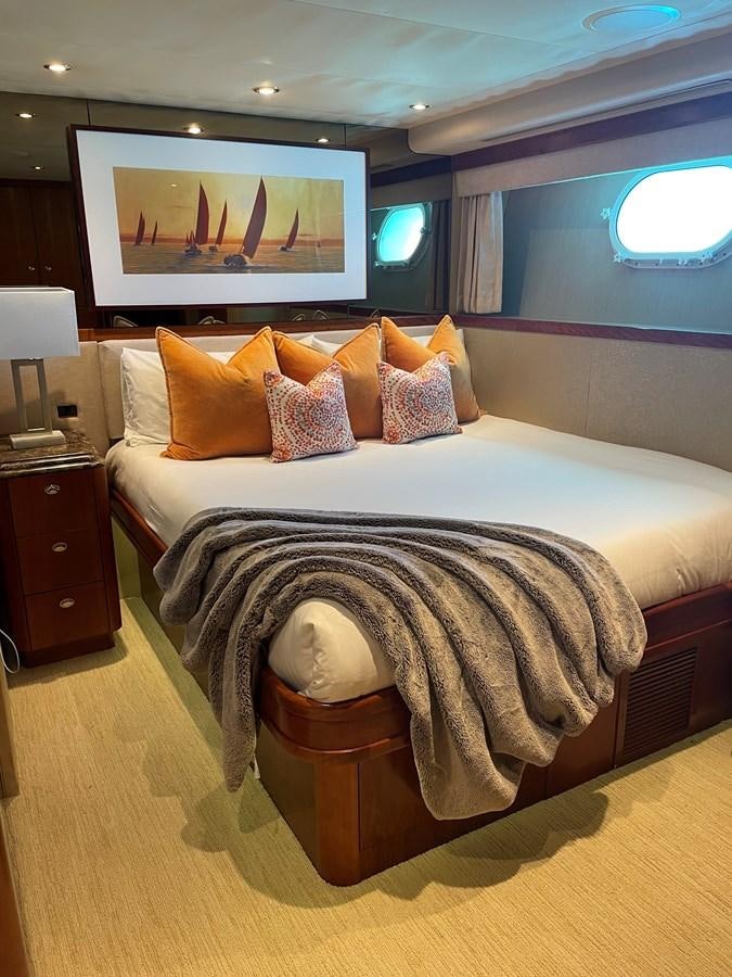 a bed with a painting on the wall aboard RELENTLESS Yacht for Sale