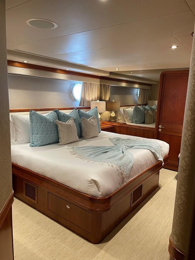 a bed with a white bed spread aboard RELENTLESS Yacht for Sale