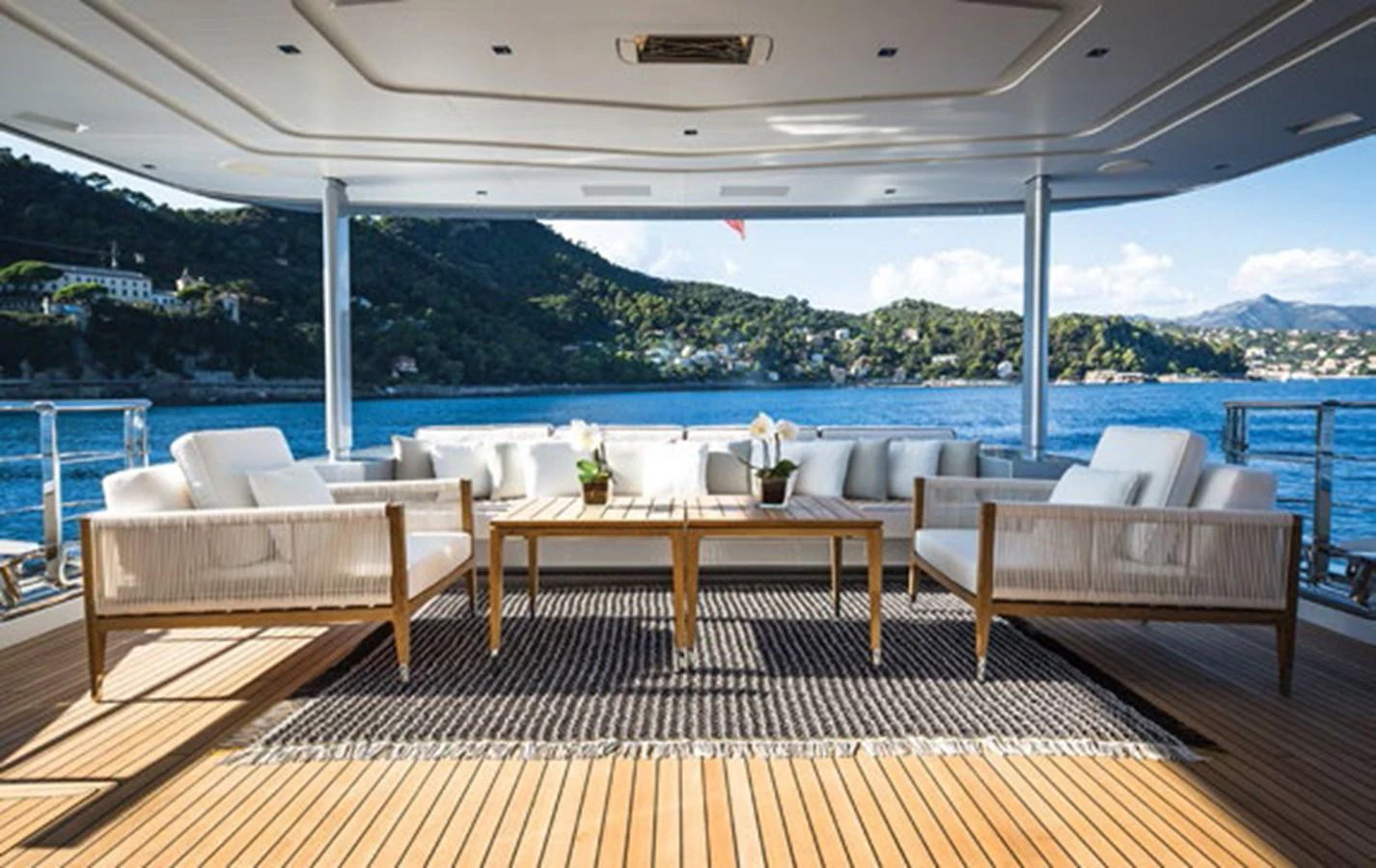 a deck with chairs and tables on it by a body of water aboard SPRING Yacht for Sale