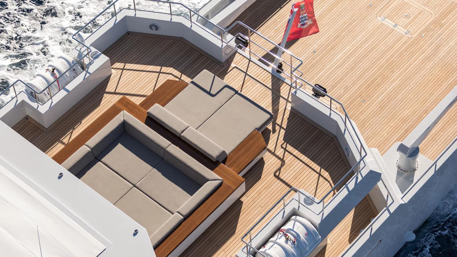 a deck with a boat and a flag on it aboard S7 Yacht for Sale
