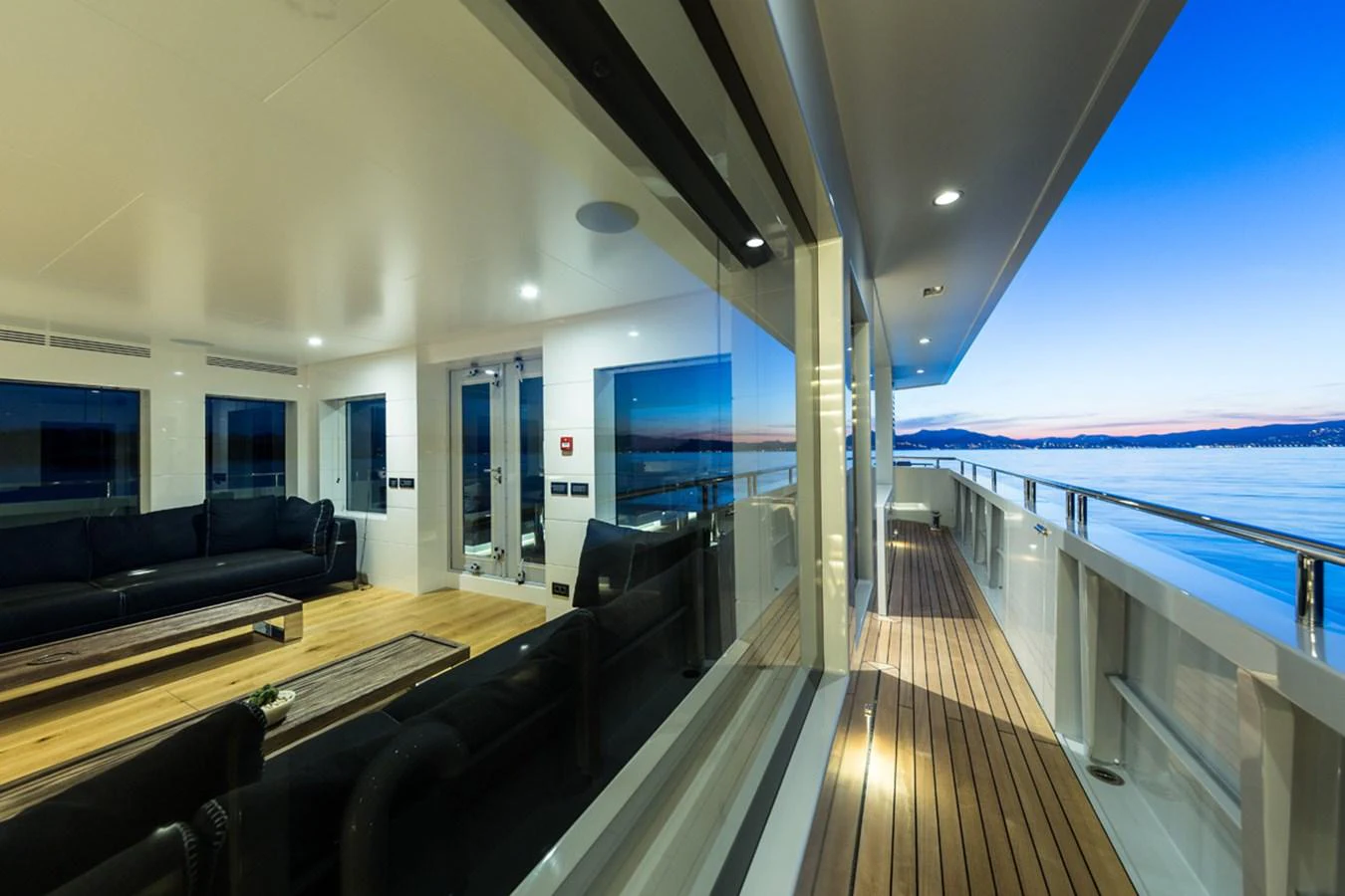 a large room with a wood deck and a large window overlooking the ocean aboard S7 Yacht for Sale