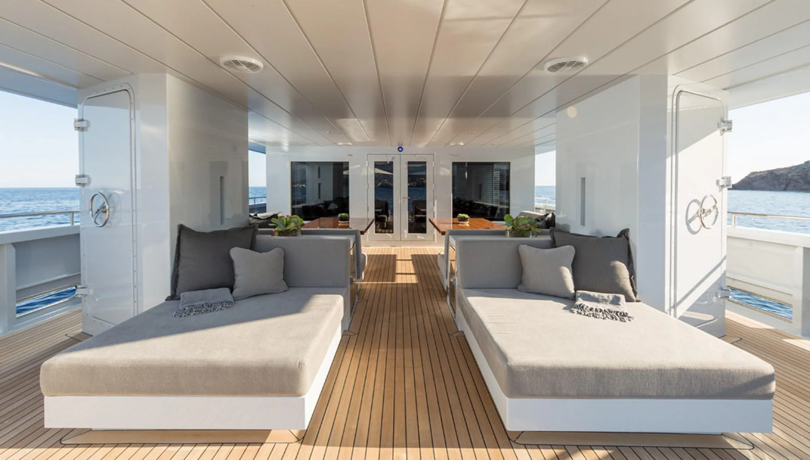 a large living room with a large white table and couches aboard S7 Yacht for Sale