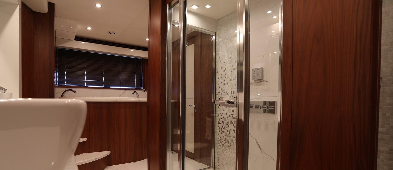 a bathroom with a glass shower aboard J & LI Yacht for Sale