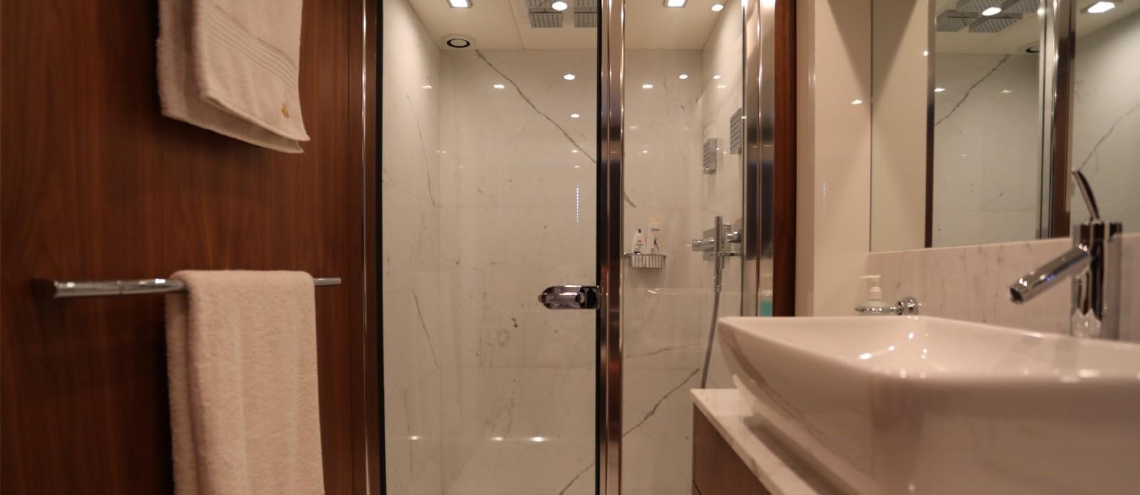 a bathroom with a glass shower aboard J & LI Yacht for Sale
