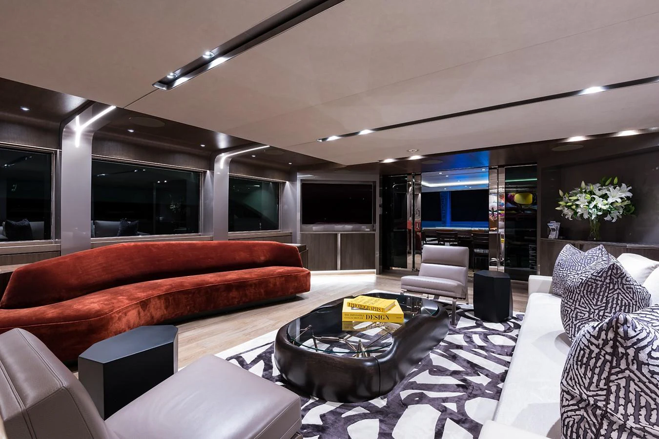 a modern living room with a large glass coffee table aboard PEPPER XIII Yacht for Sale