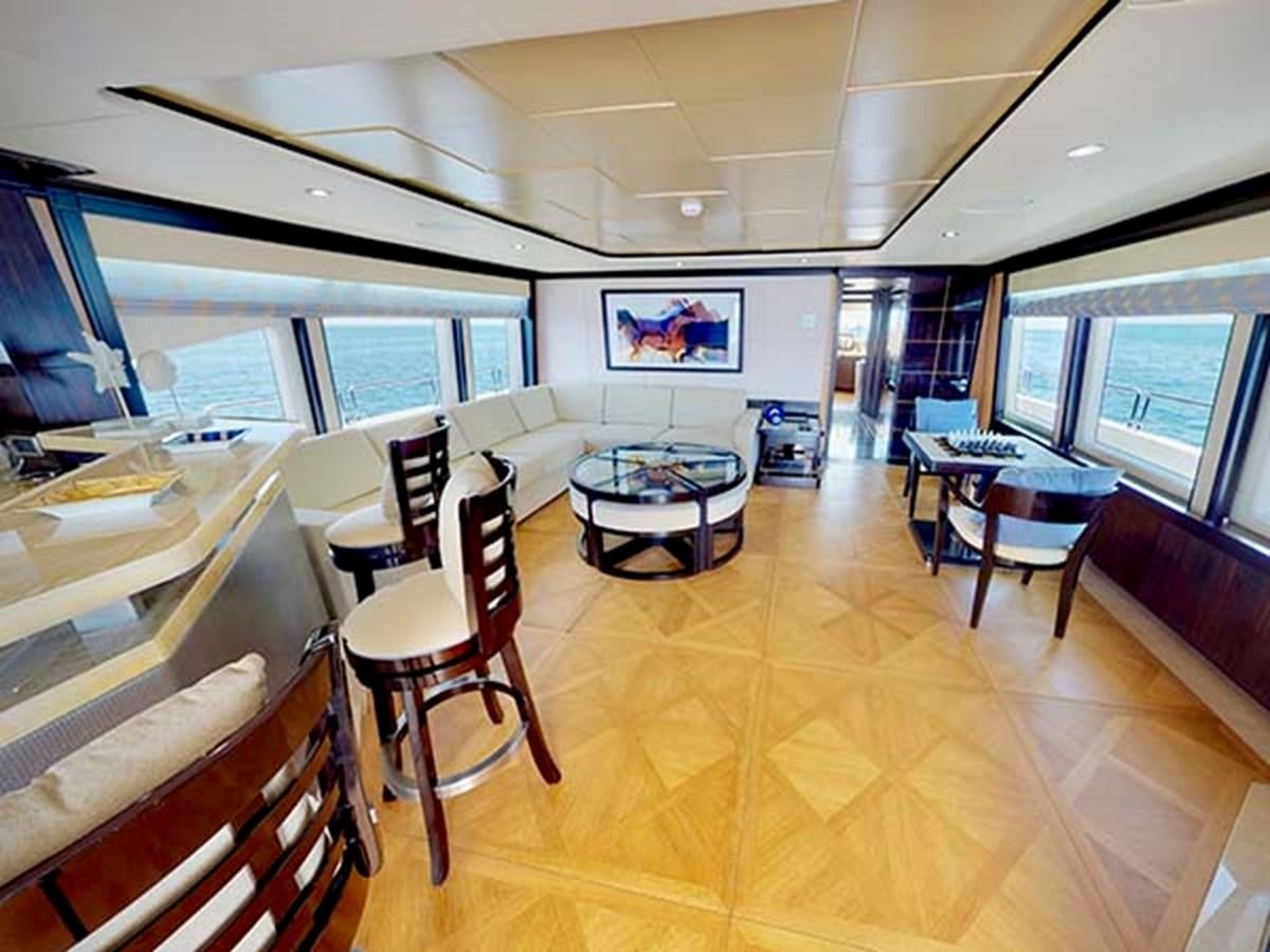 a room with a table chairs and a television aboard AL WASMY I Yacht for Sale