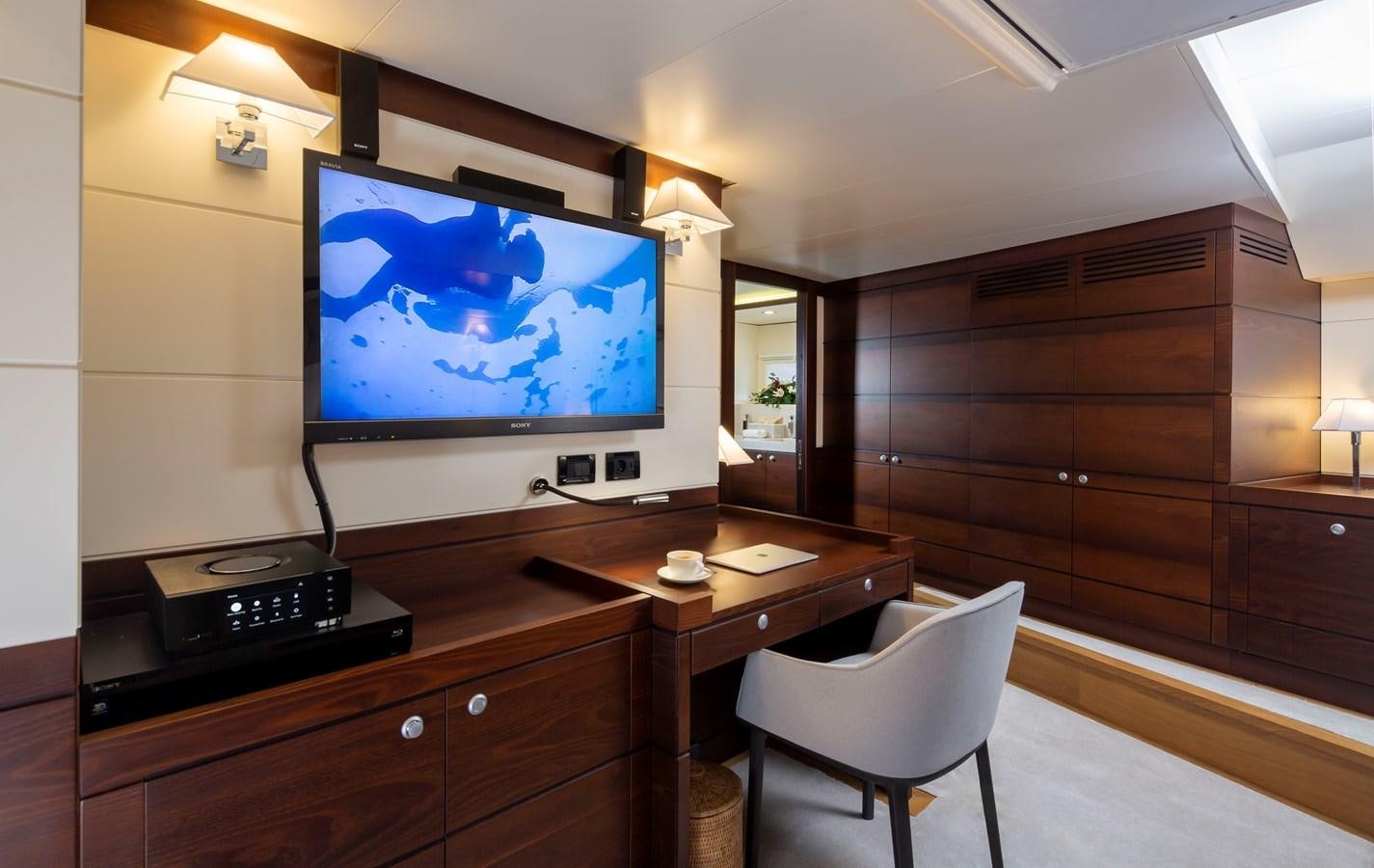 a room with a tv and a chair aboard RADIANCE Yacht for Sale
