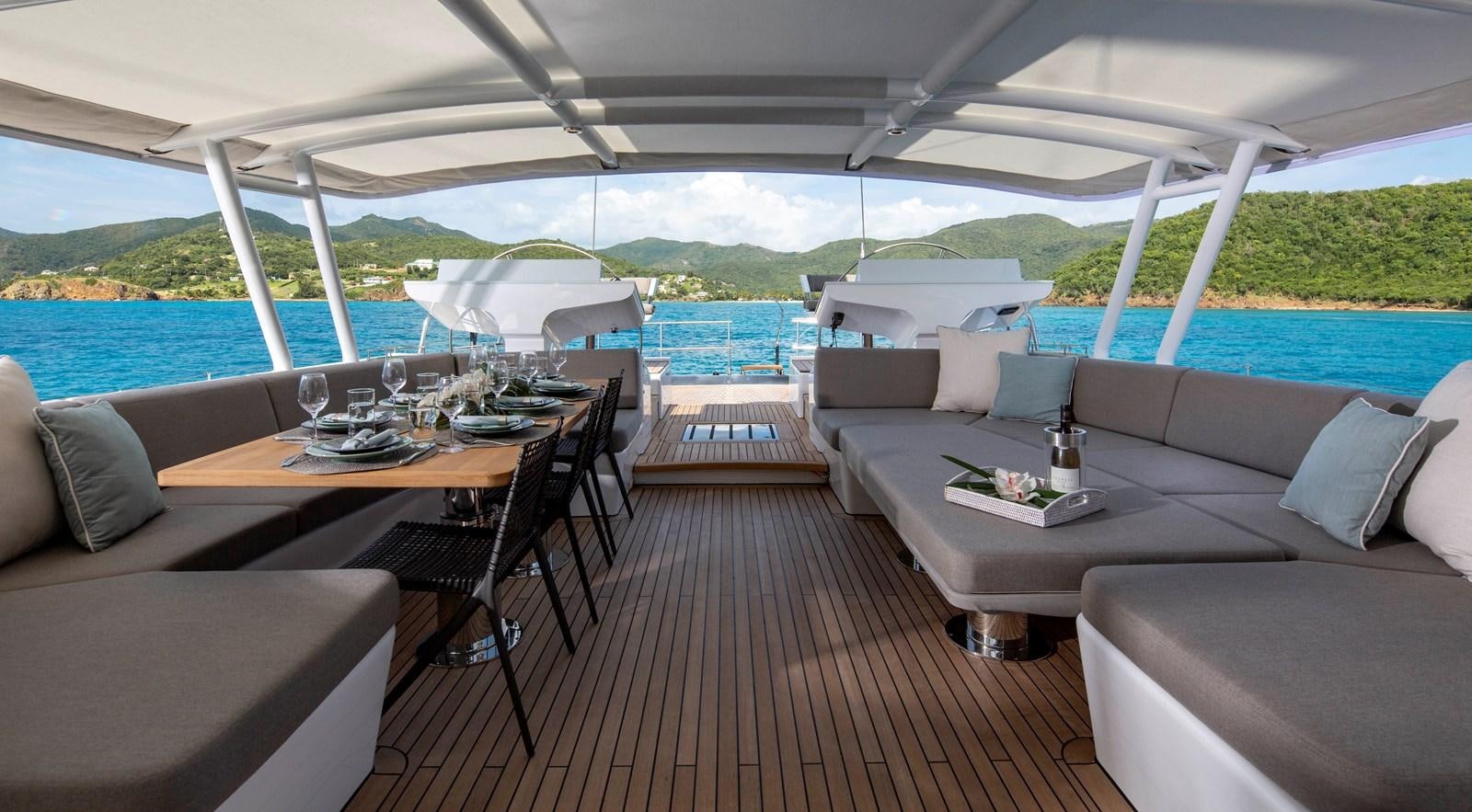 a deck with a table and chairs aboard RADIANCE Yacht for Sale