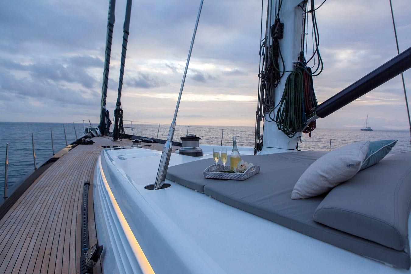 a deck with a boat and a bottle of beer on it aboard RADIANCE Yacht for Sale
