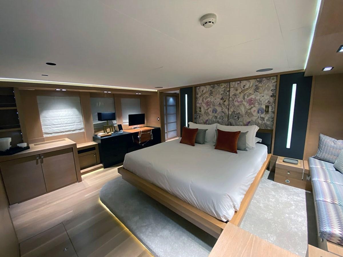 a room with a bed and desk aboard ESCAPE Yacht for Sale