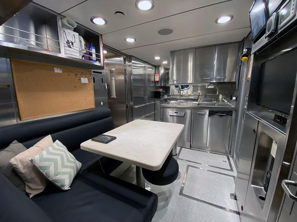 a kitchen with a couch and a table aboard ESCAPE Yacht for Sale
