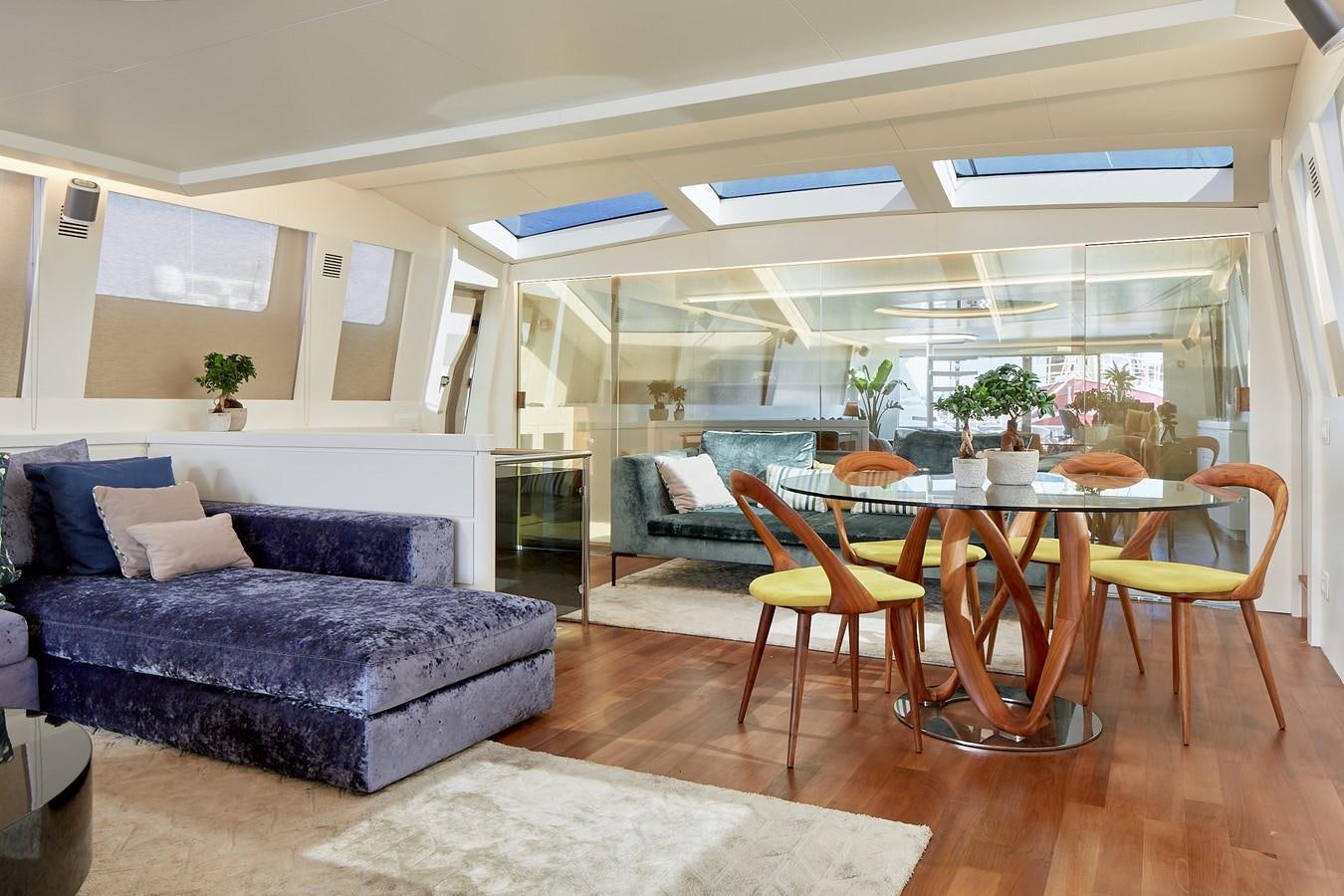 a living room with a blue couch and a table aboard EVA Yacht for Sale