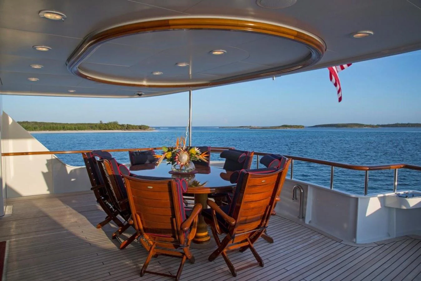 a table and chairs on a deck overlooking a body of water aboard LADY VICTORIA Yacht for Sale