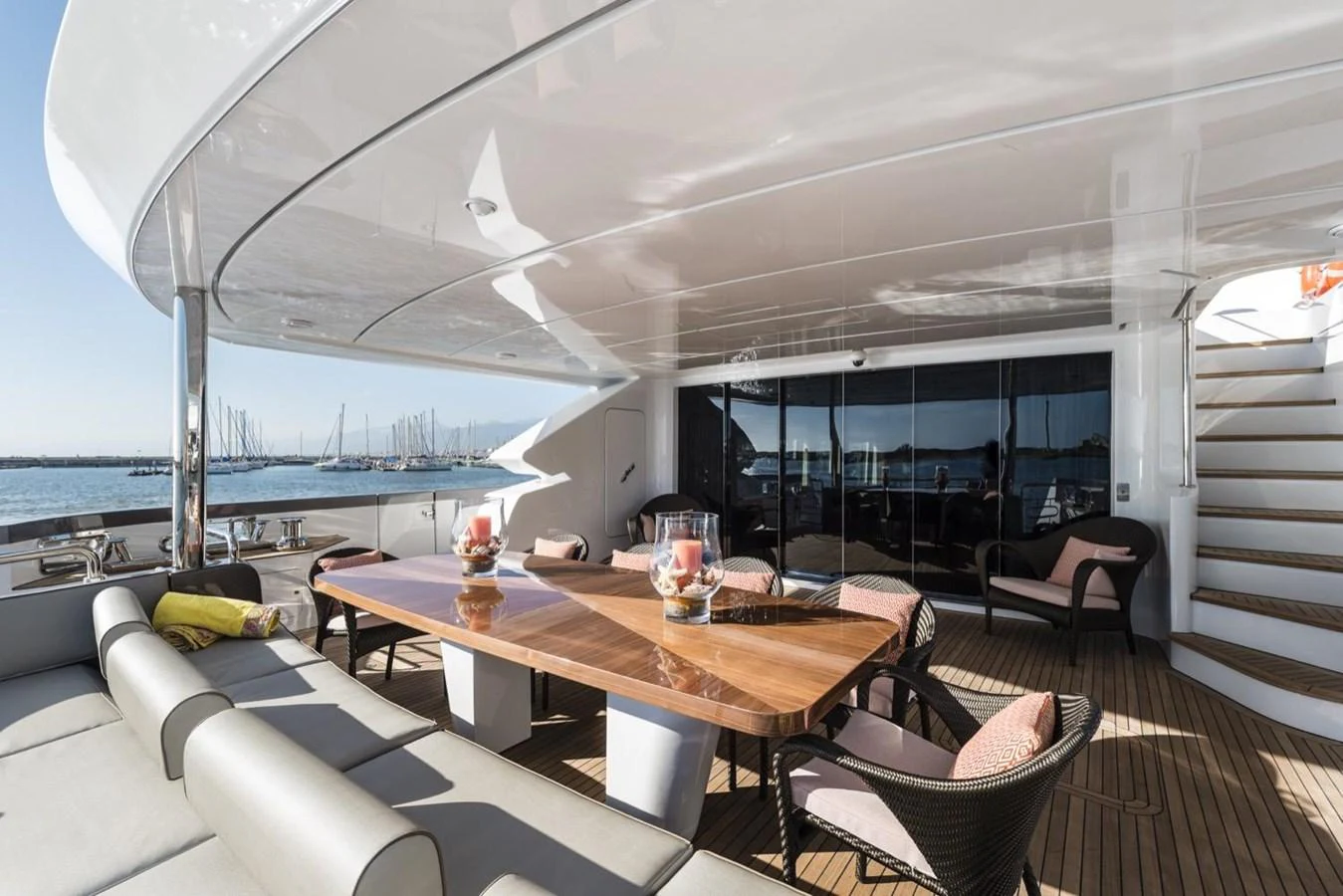 a table with a glass window overlooking a beach aboard HARMONY Yacht for Sale