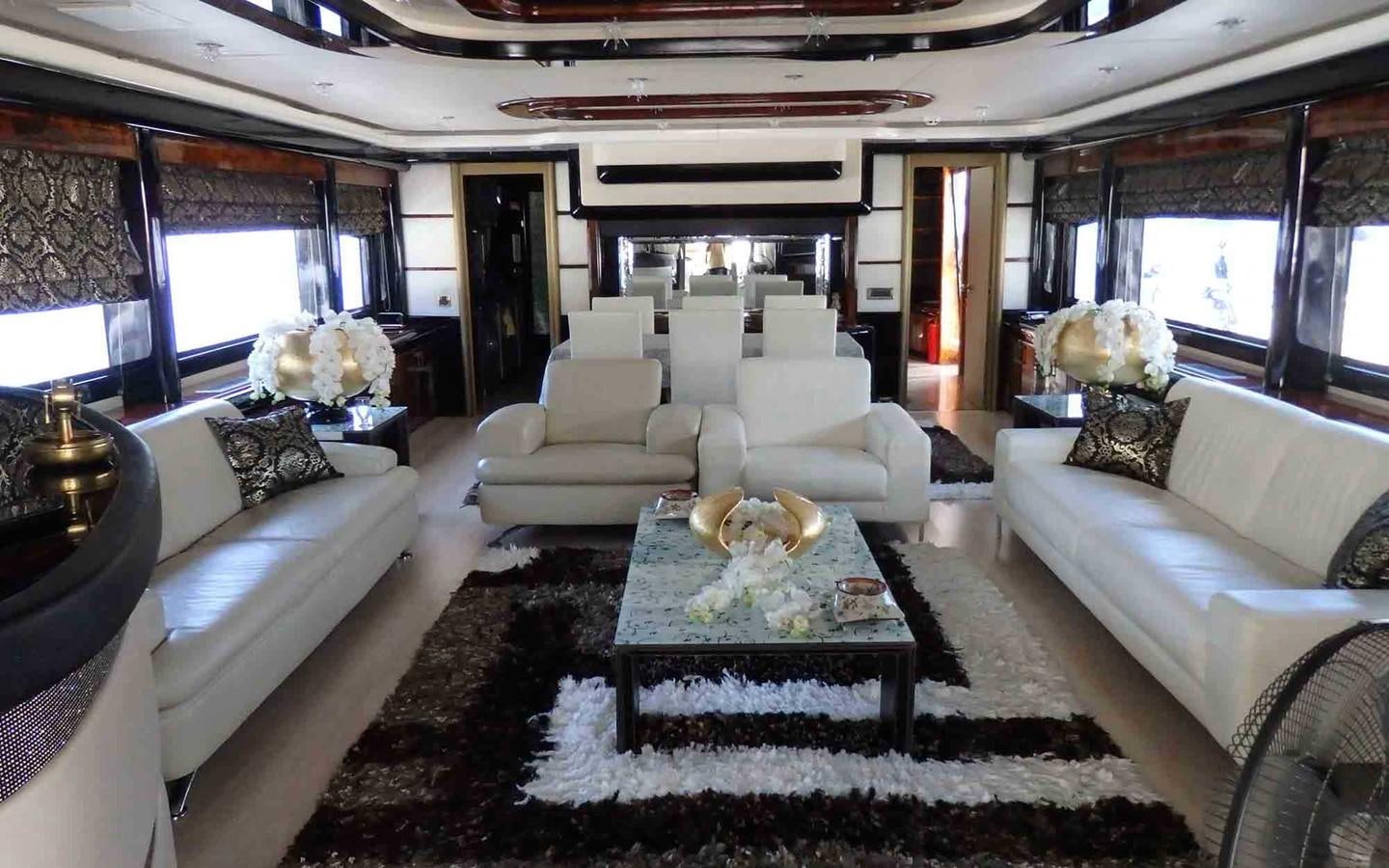 a living room with a large white couch and a table aboard ETERNITY Yacht for Sale
