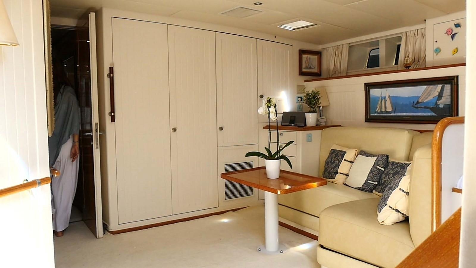 a room with a table and couch aboard INGENIOUS Yacht for Sale
