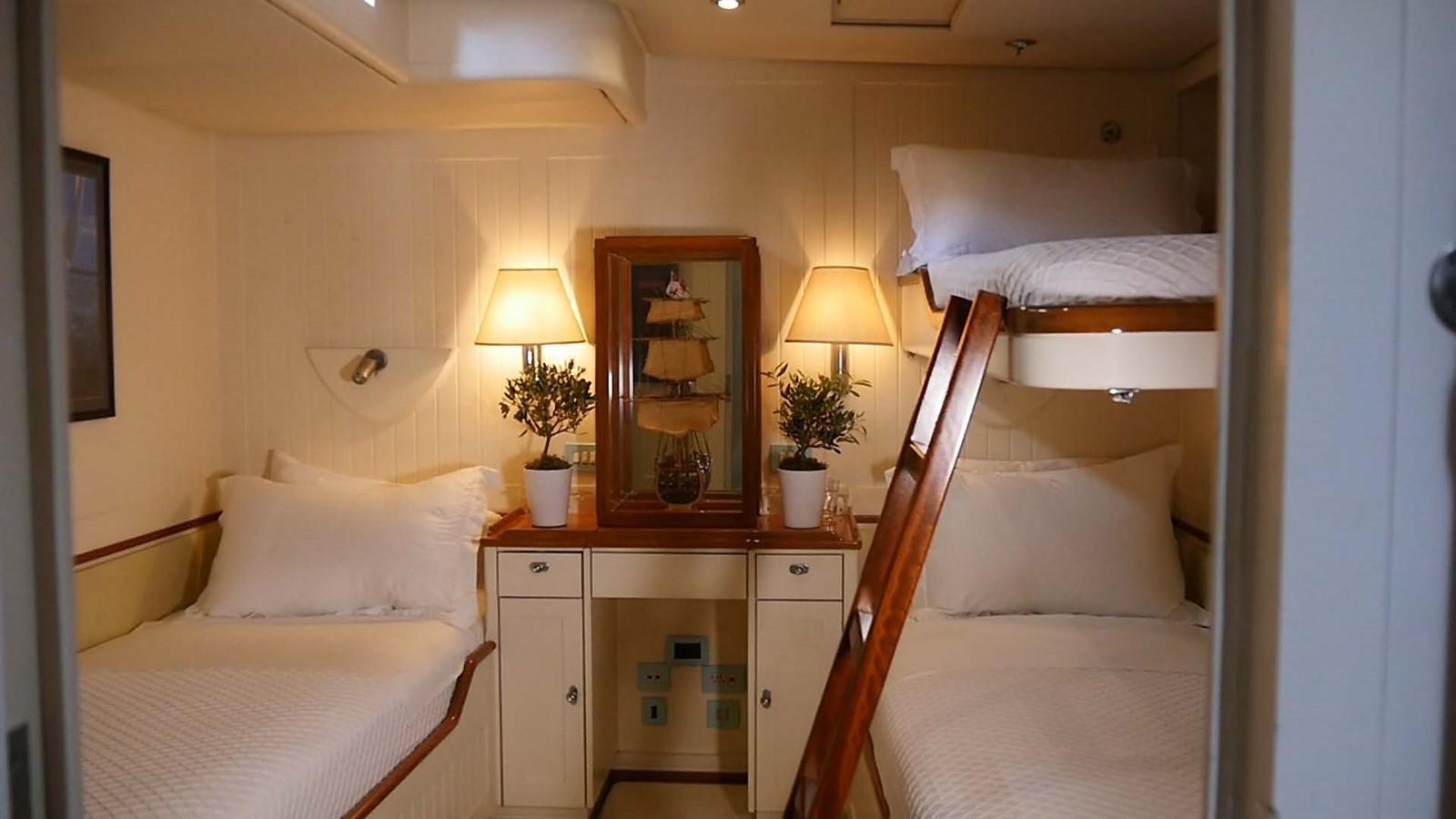 a room with a bed and a desk aboard INGENIOUS Yacht for Sale